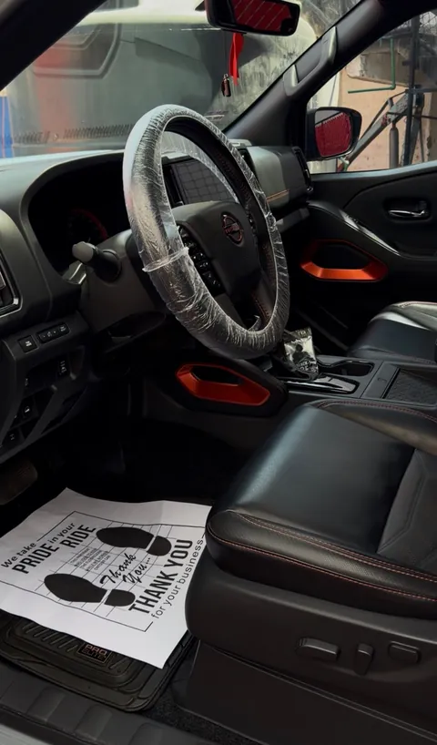 Interior de una pickup Nissan limpio, con el volante protegido
